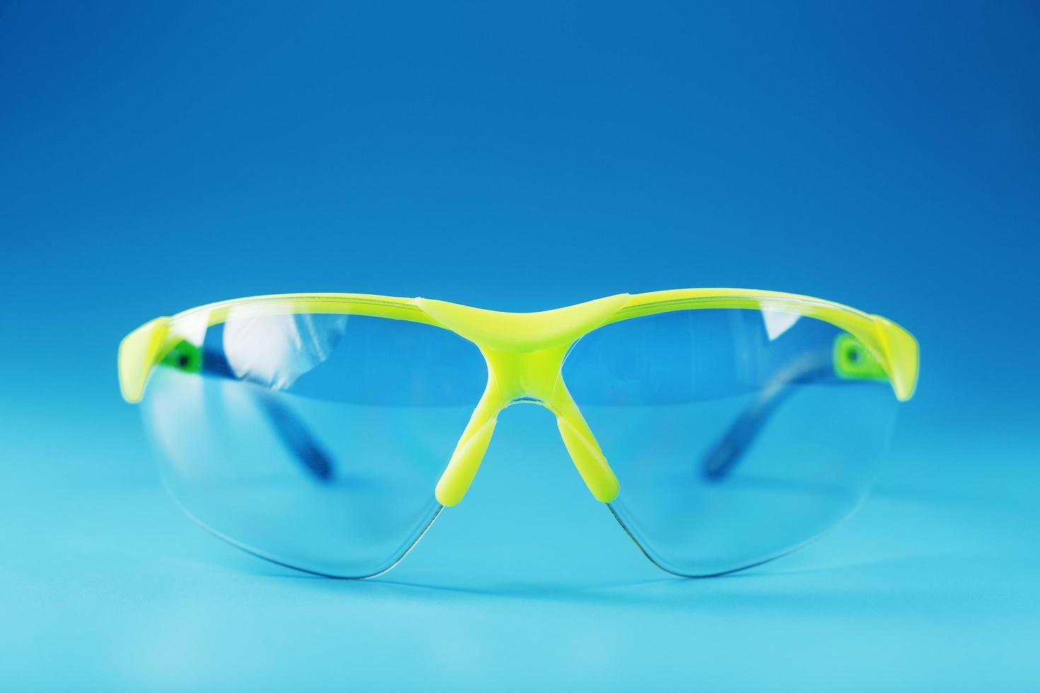 gafas verdes protectoras tecnológicas aisladas en un fondo azul. foto