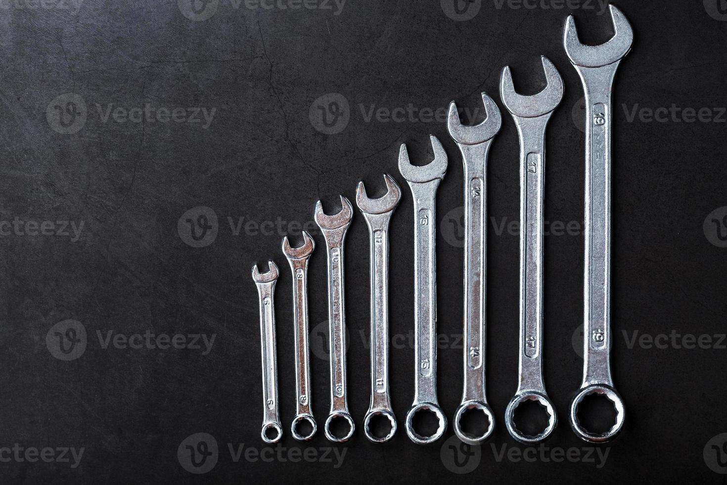 Tool wrenches in a row on a black background with free space. photo