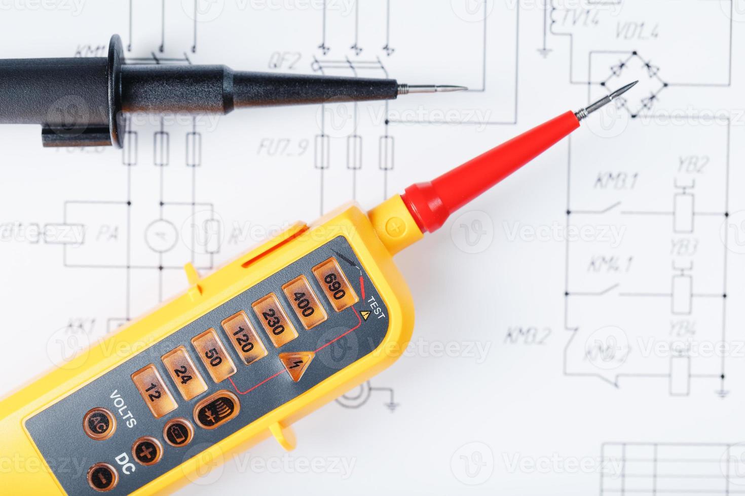 The two-pole voltage indicator lies on the electrical drawing. photo