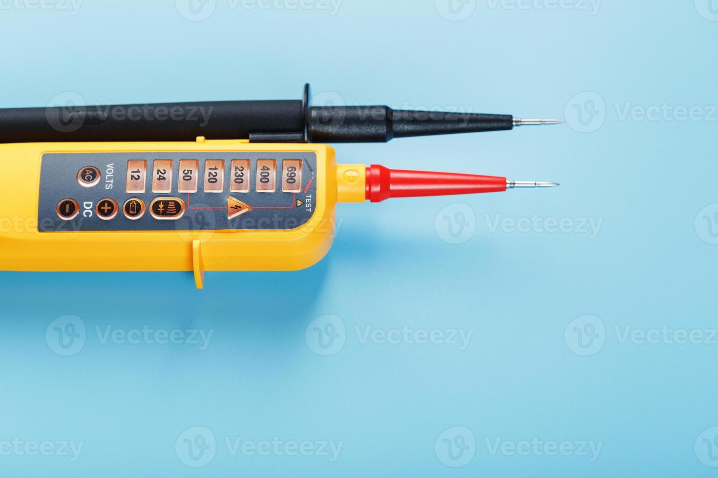 Yellow tester for step-by-step indication of voltage in an electrical circuit on a blue background photo