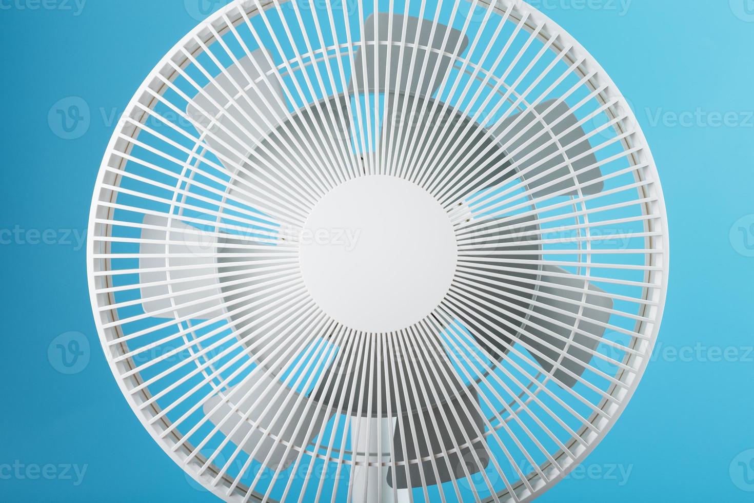 Electric fan in white with a modern design for cooling the room on a blue background photo