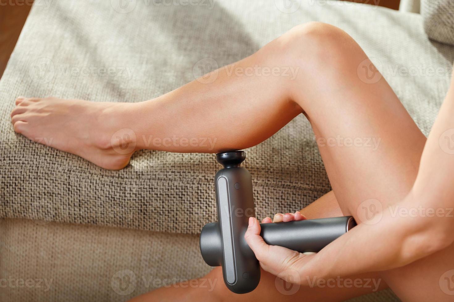 Massage of women's legs with a shock massage device. photo