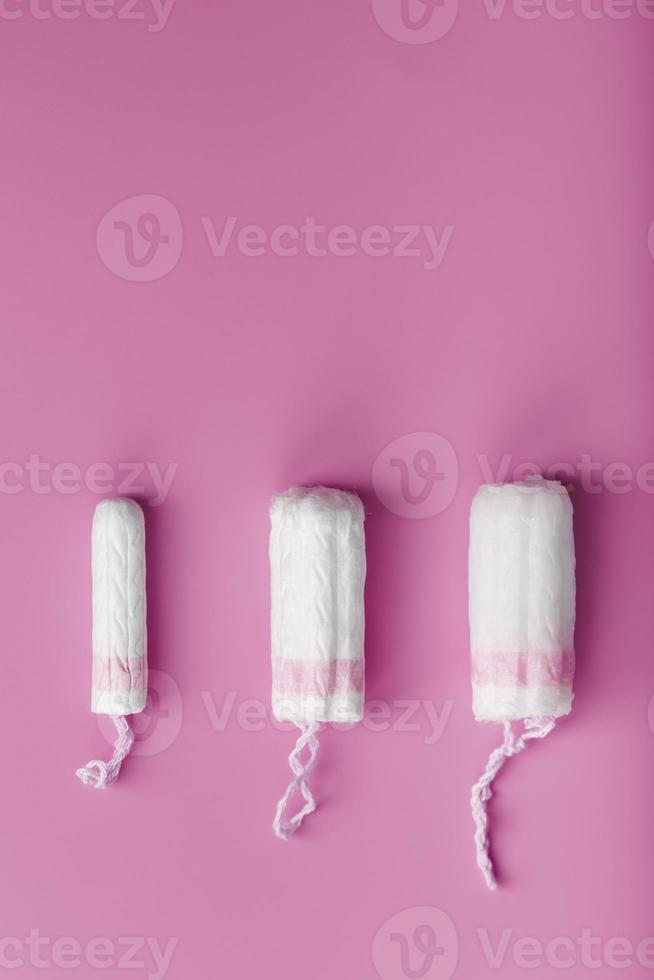 Cotton tampons on a pink background with a free space photo