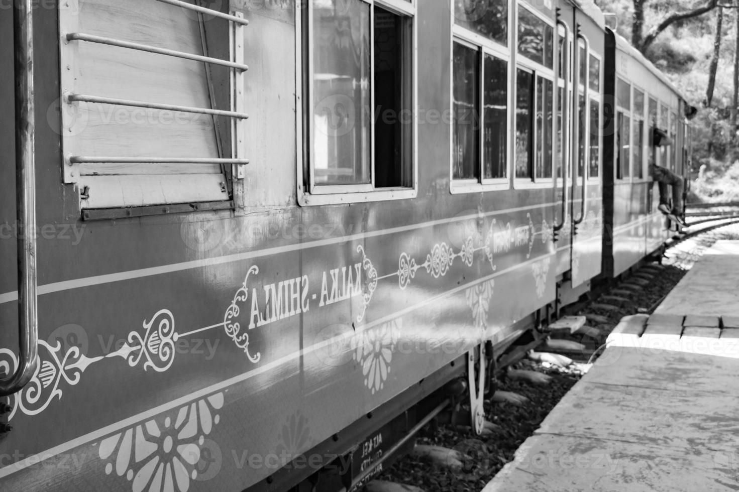Toy Train moving on mountain slope, beautiful view, one side mountain, one side valley moving on railway to the hill, among green natural forest.Toy train from Kalka to Shimla in India-Black and White photo