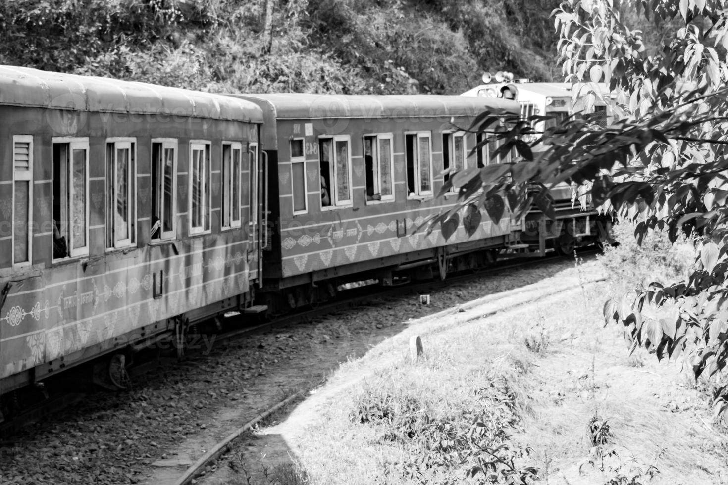 Toy Train moving on mountain slope, beautiful view, one side mountain, one side valley moving on railway to the hill, among green natural forest.Toy train from Kalka to Shimla in India-Black and White photo