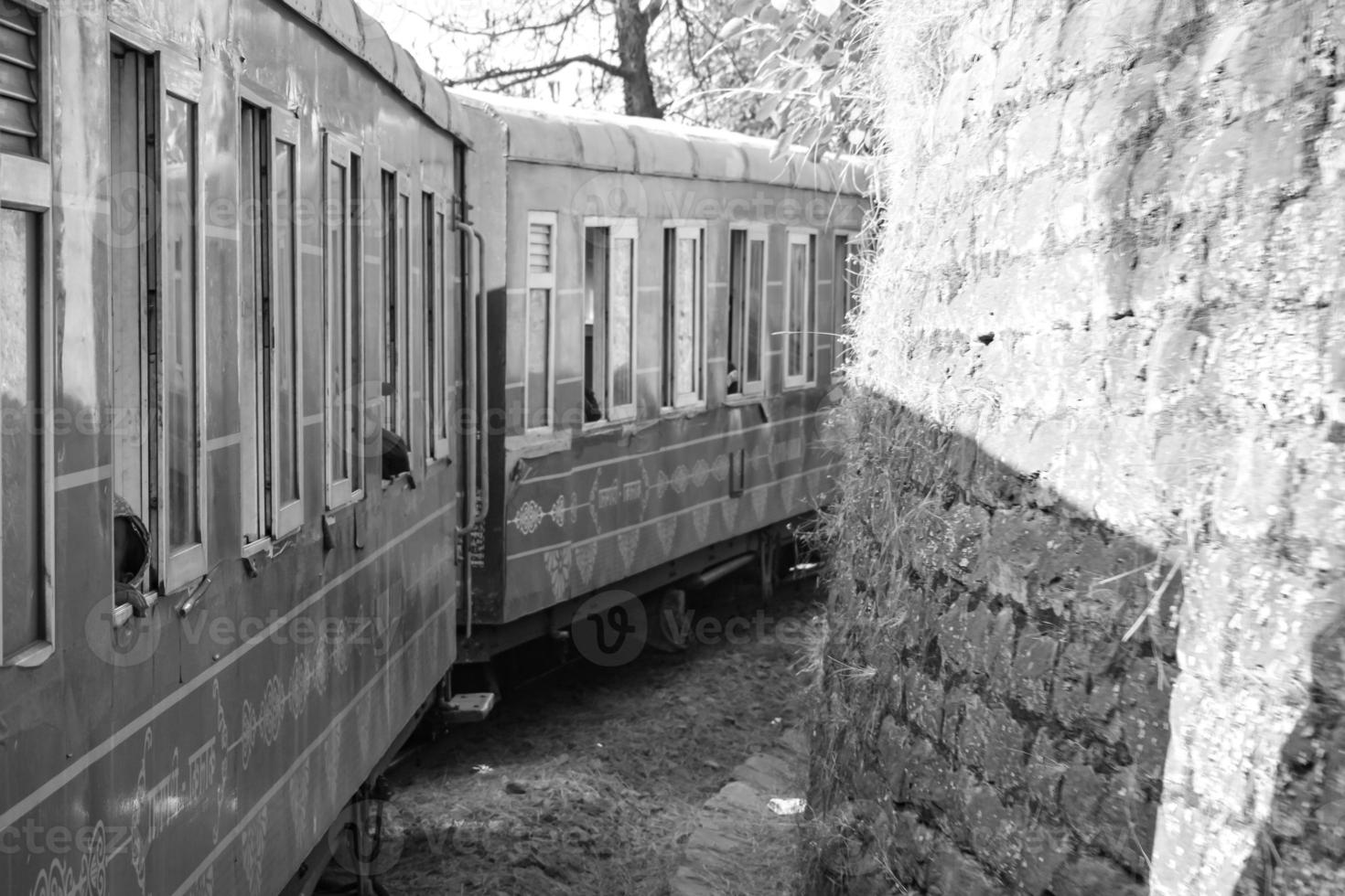 Toy Train moving on mountain slope, beautiful view, one side mountain, one side valley moving on railway to the hill, among green natural forest.Toy train from Kalka to Shimla in India-Black and White photo