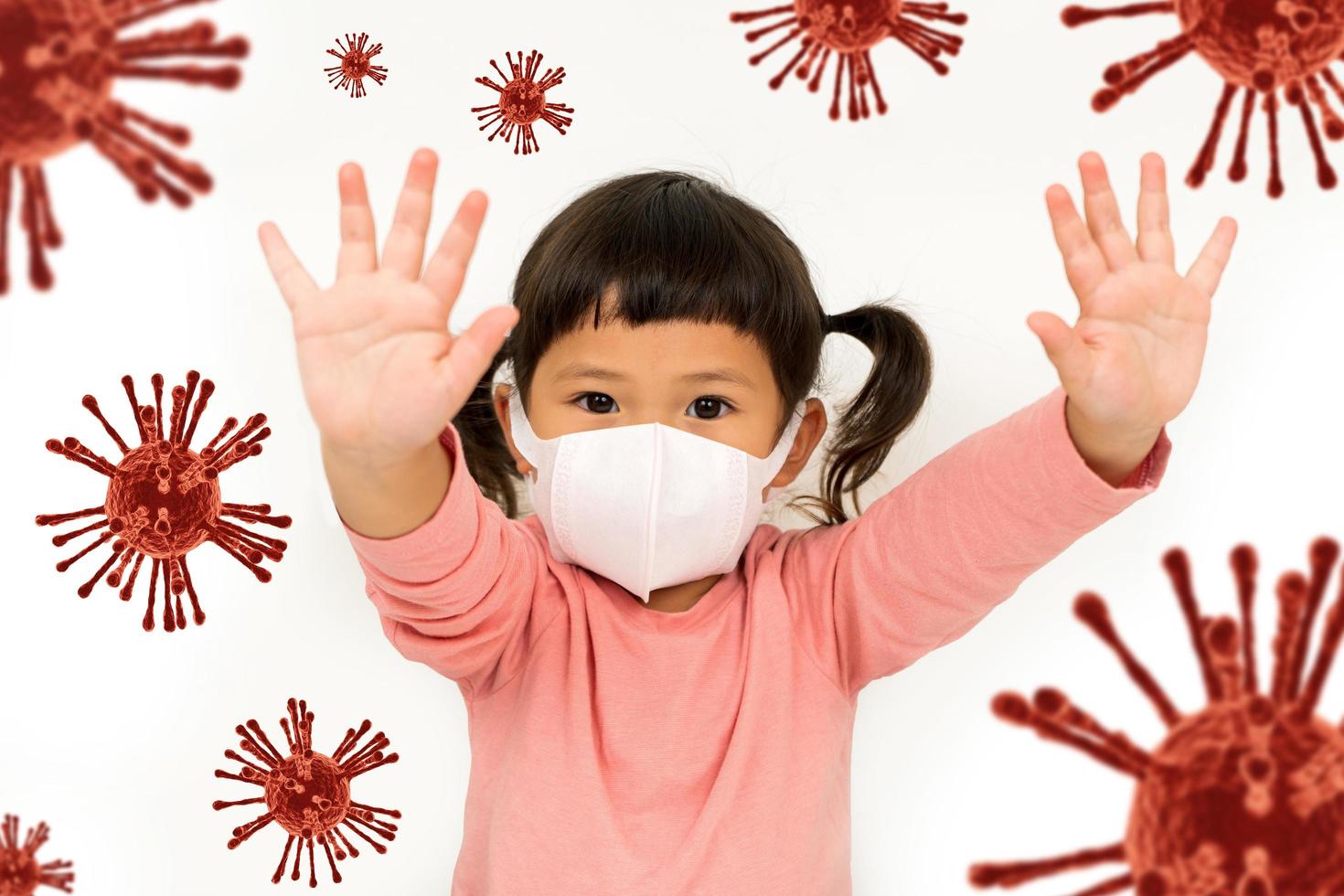 Little asian girl  wearing mask for protect Virus and show stop hands gesture for stop corona virus outbreak photo