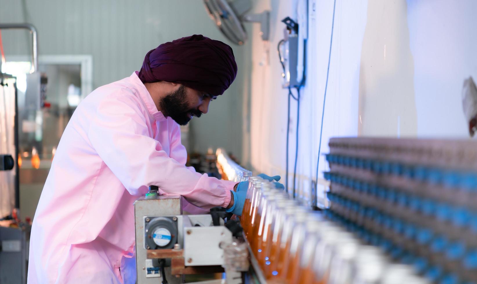 Product quality control staff at the fruit juice production line Perform product quality checks To ensure that the products produced are of good quality photo