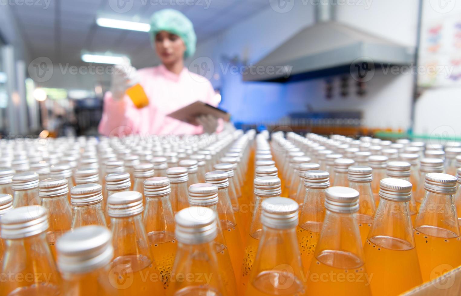 el personal de control de calidad del producto en la línea de producción de jugo de frutas realiza controles de calidad del producto para garantizar que los productos producidos sean de buena calidad foto