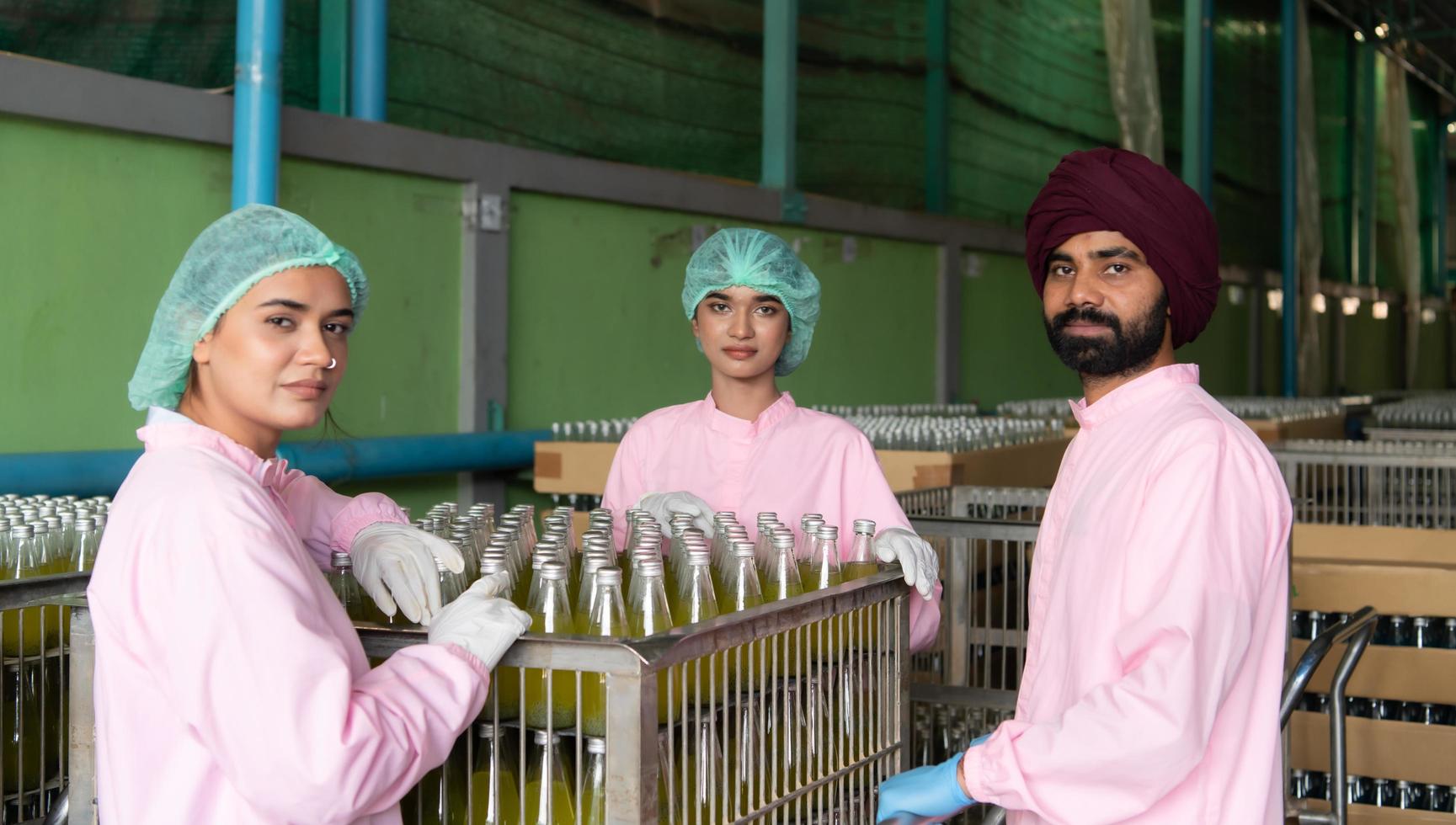 Product quality control staff at the fruit juice production line Perform product quality checks To ensure that the products produced are of good quality photo