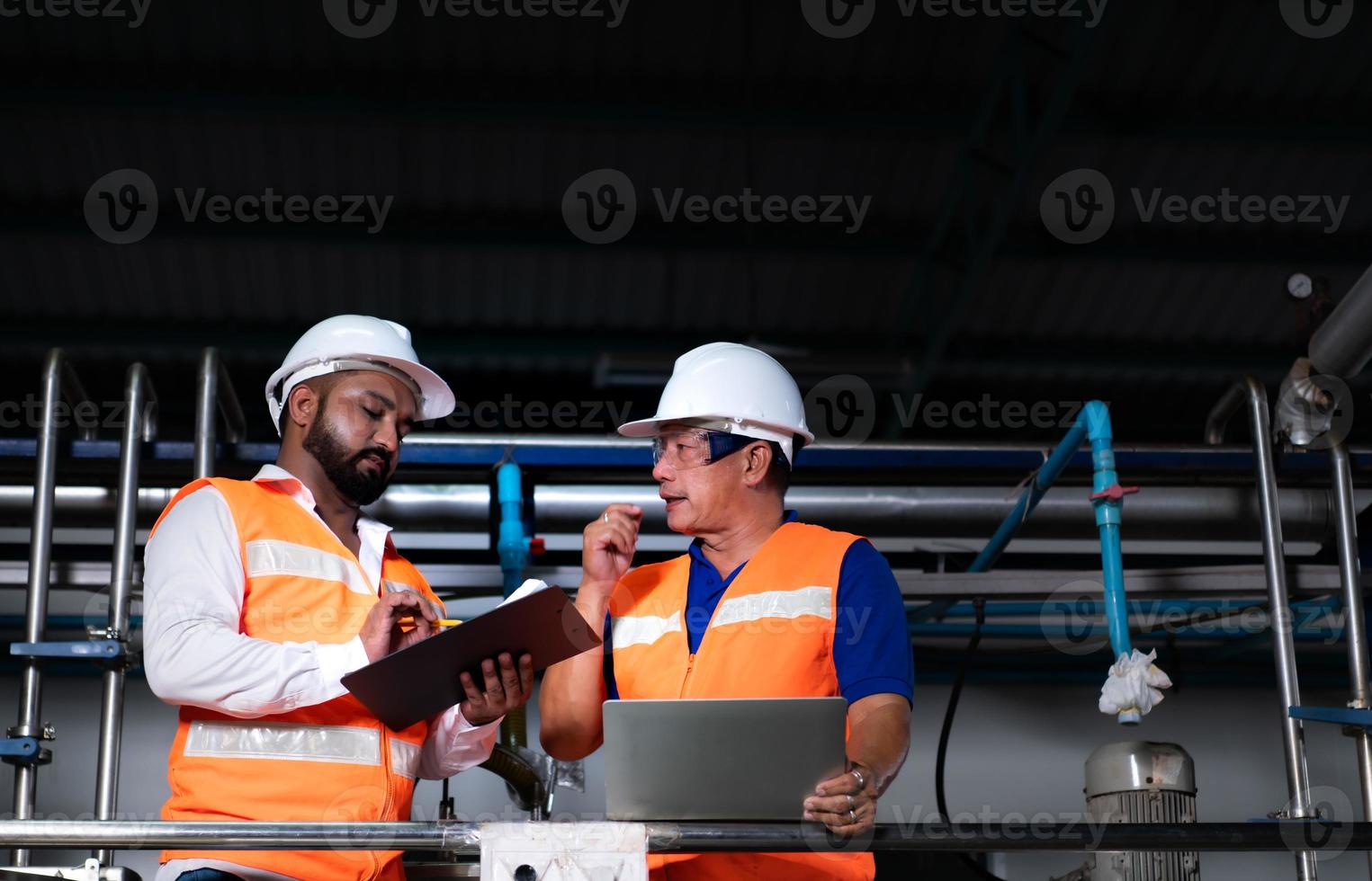 Chief engineer of a mechanical plant Inspecting and explaining the maintenance of the machine to the mechanic photo