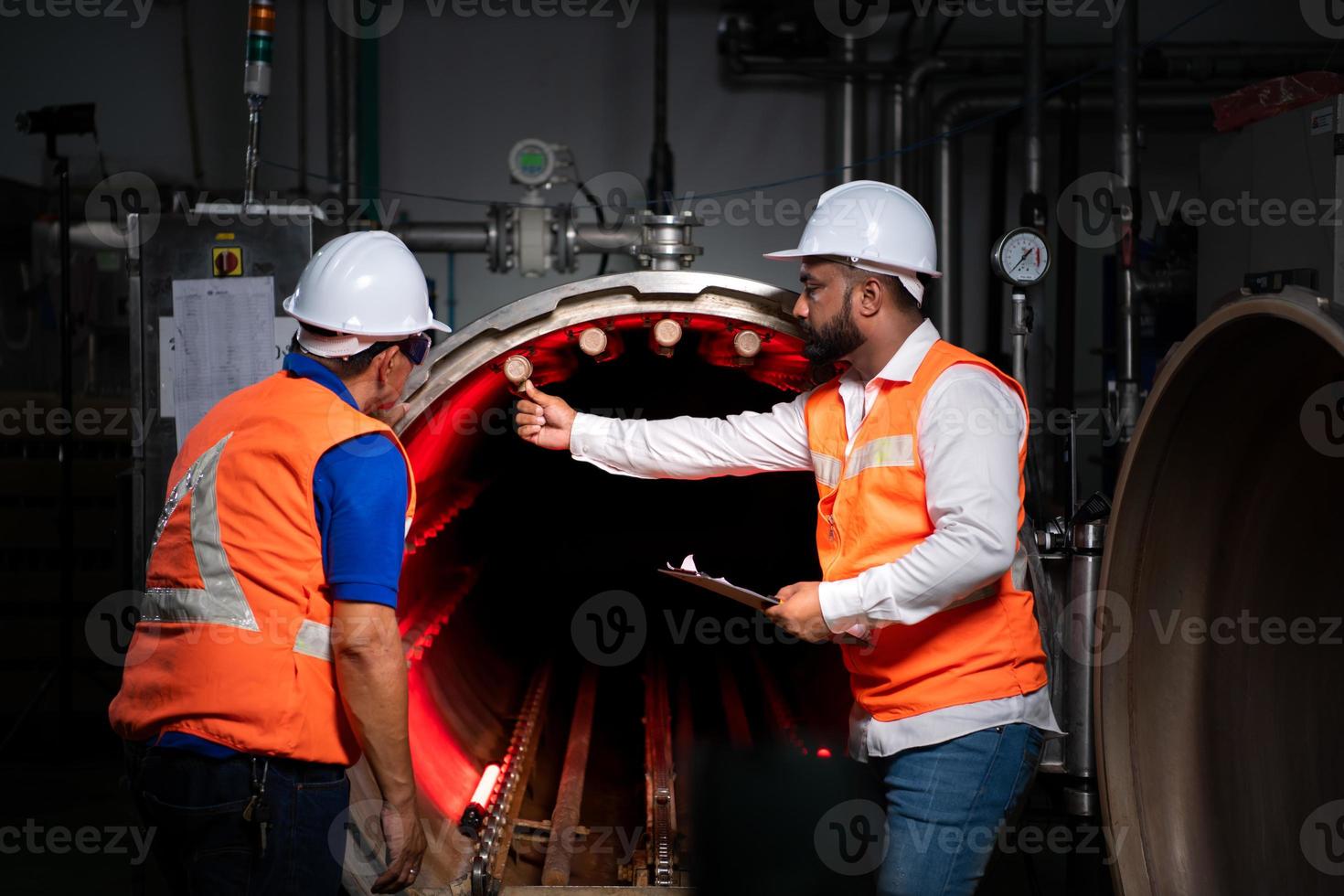 Chief engineer of a mechanical plant Inspecting and explaining the maintenance of the machine to the mechanic photo