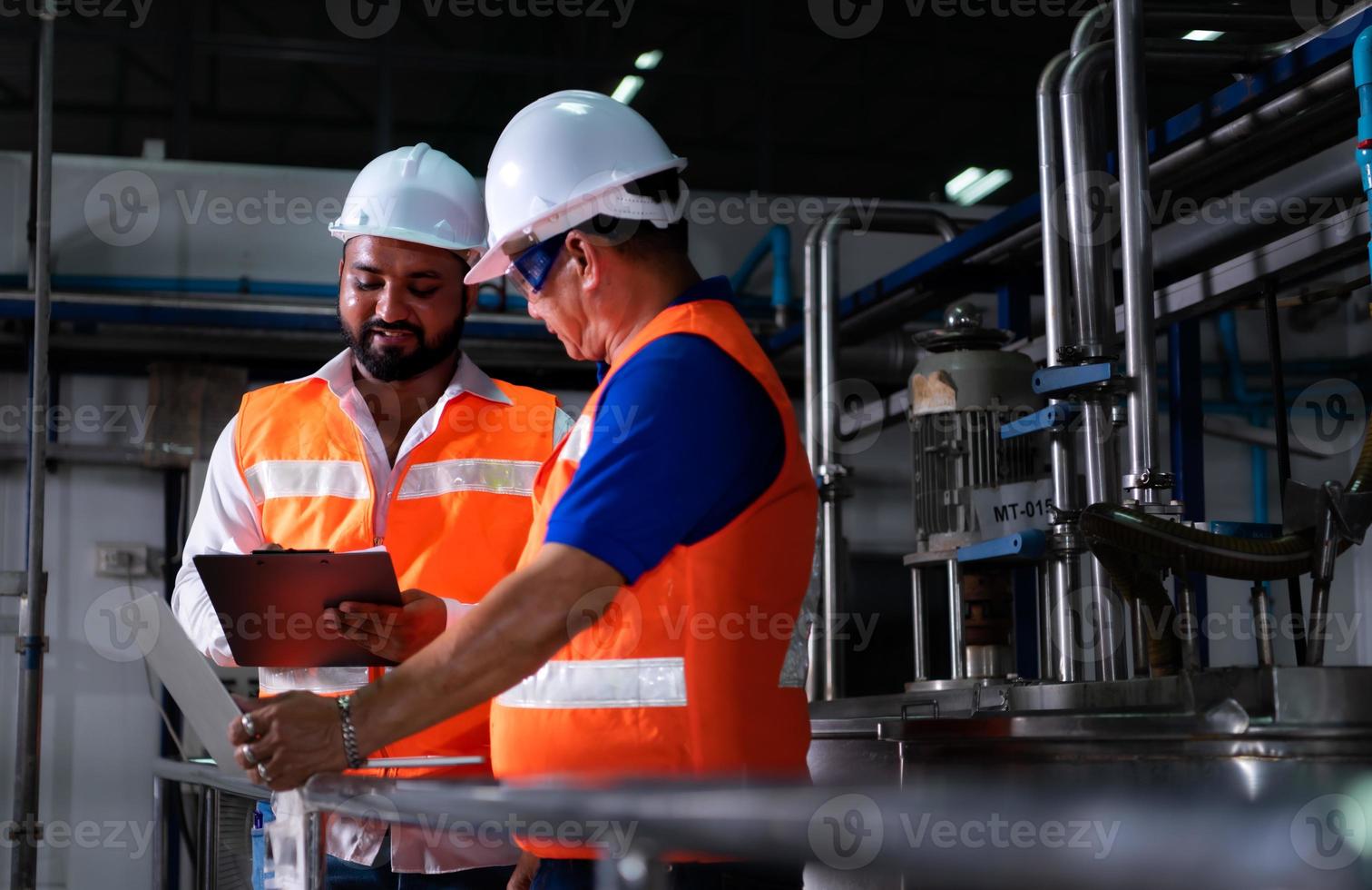 Chief engineer of a mechanical plant Inspecting and explaining the maintenance of the machine to the mechanic photo
