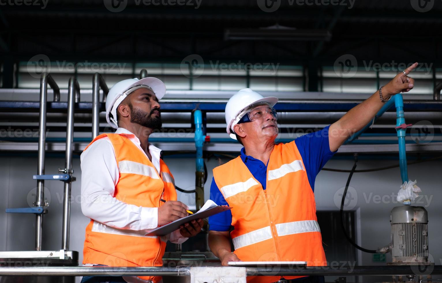Chief engineer of a mechanical plant Inspecting and explaining the maintenance of the machine to the mechanic photo