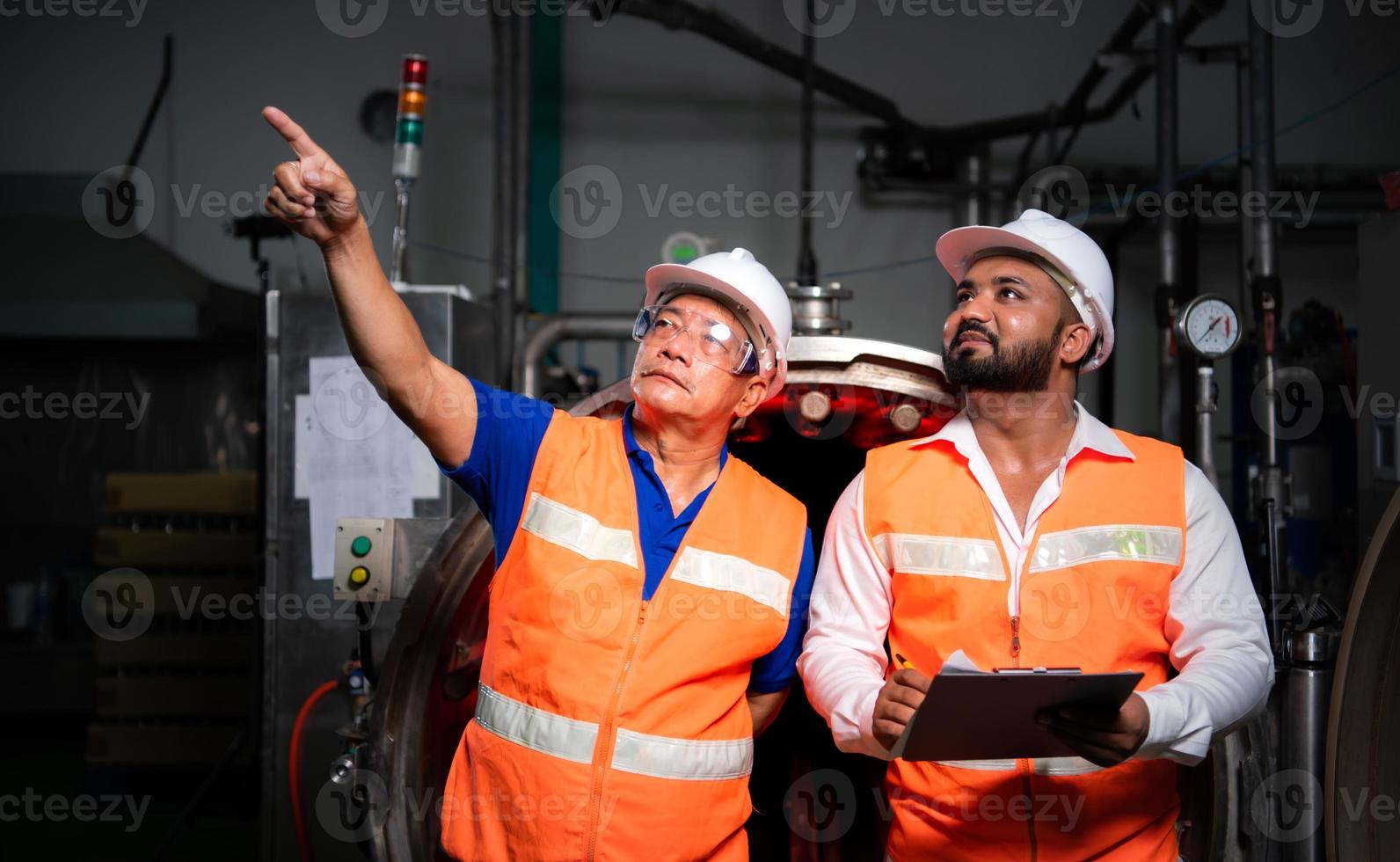 Chief engineer of a mechanical plant Inspecting and explaining the maintenance of the machine to the mechanic photo
