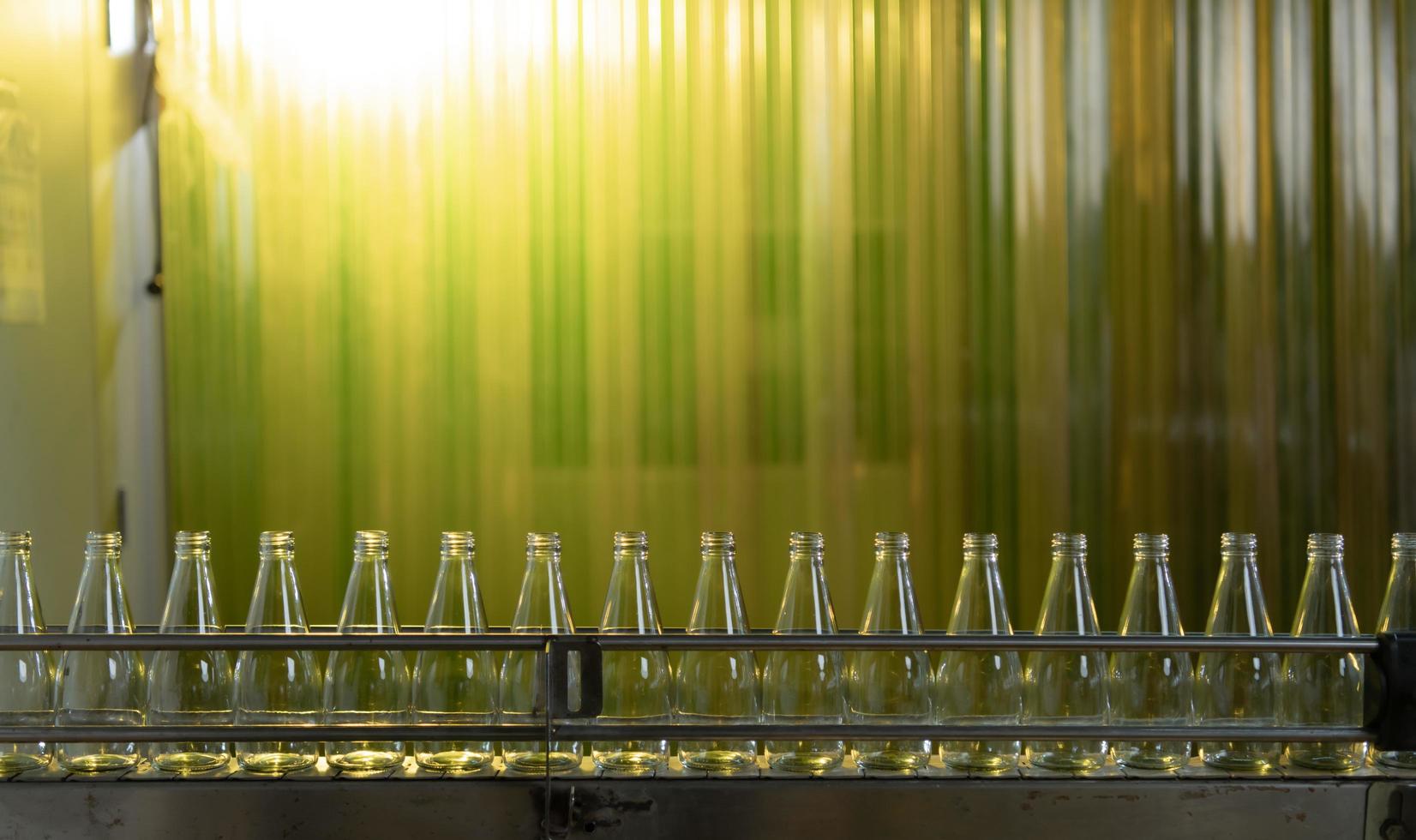 Product quality control officer in fruit juice production line Carry out an inspection of bottles used to contain fruit juices photo