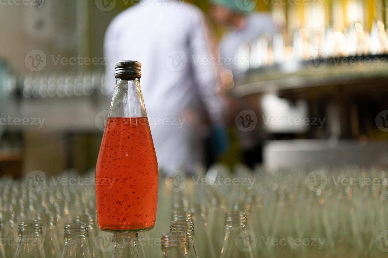 Product quality control officer in fruit juice production line Carry out an inspection of bottles used to contain fruit juices photo