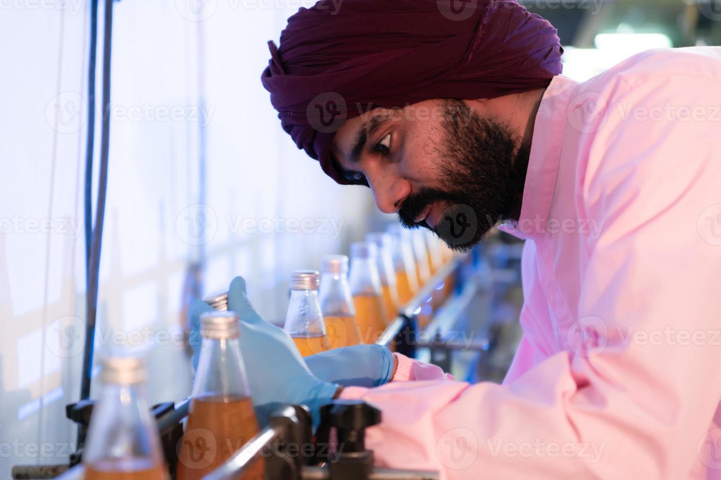 el personal de control de calidad del producto en la línea de producción de jugo de frutas realiza controles de calidad del producto para garantizar que los productos producidos sean de buena calidad foto