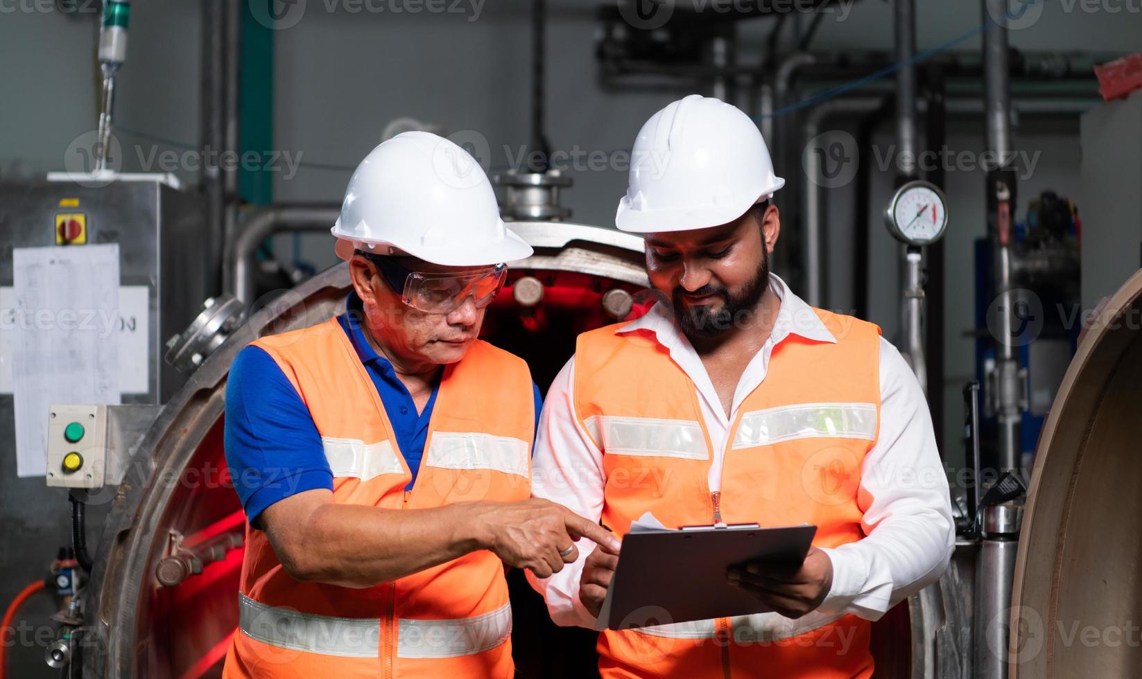 Chief engineer of a mechanical plant Inspecting and explaining the maintenance of the machine to the mechanic photo