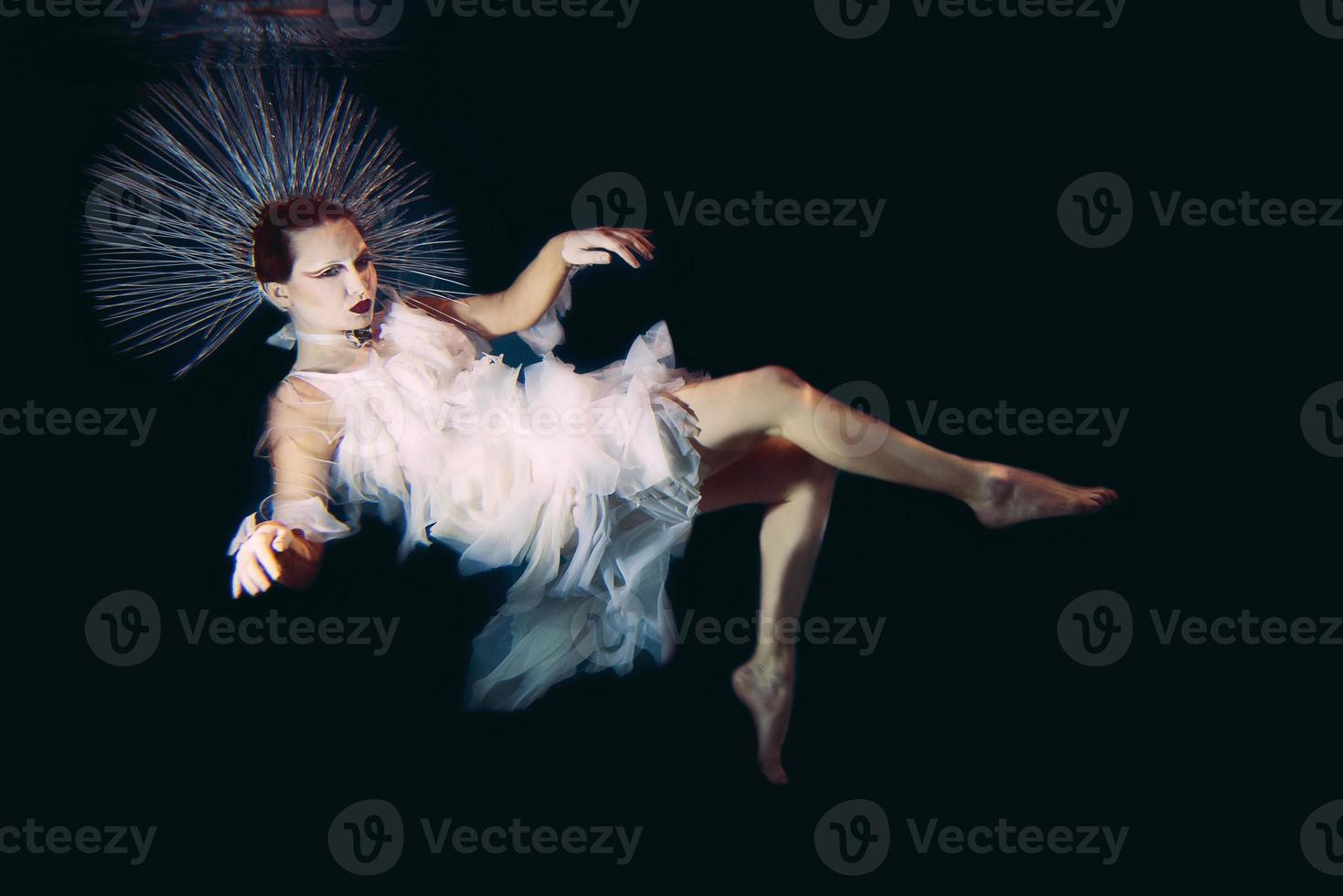 Beautiful woman with red lips and in women's jewellery underwater as the Virgin Mary photo