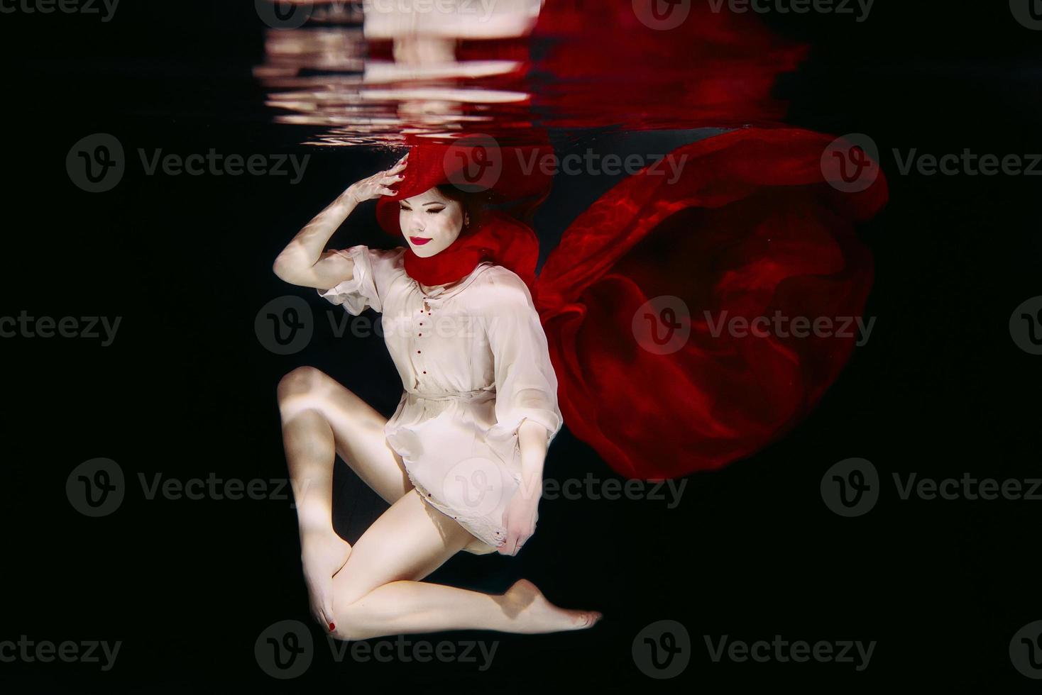 mujer con sombrero rojo y bufanda roja bajo el agua foto