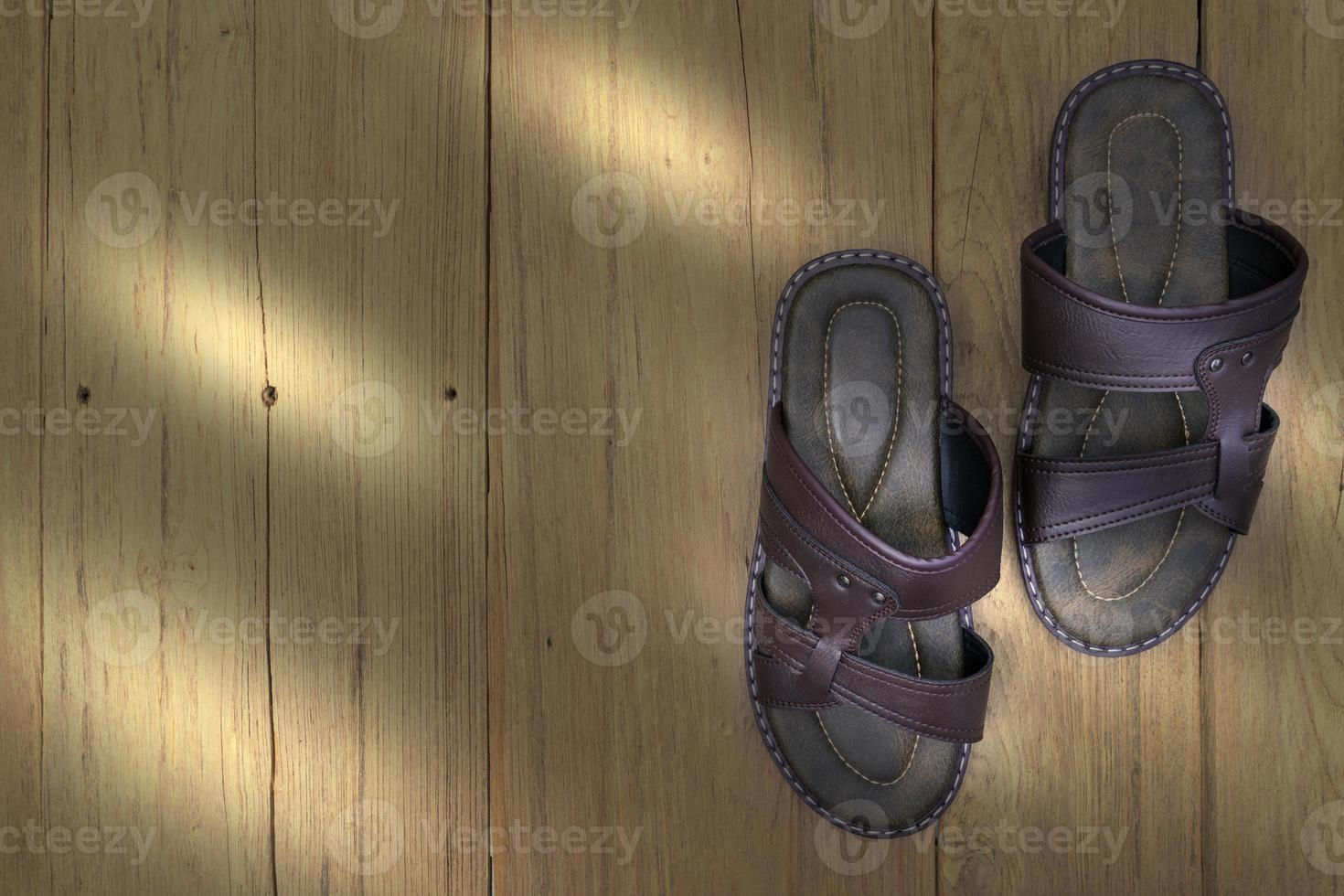 Brown leather slippers on wood background,top view photo