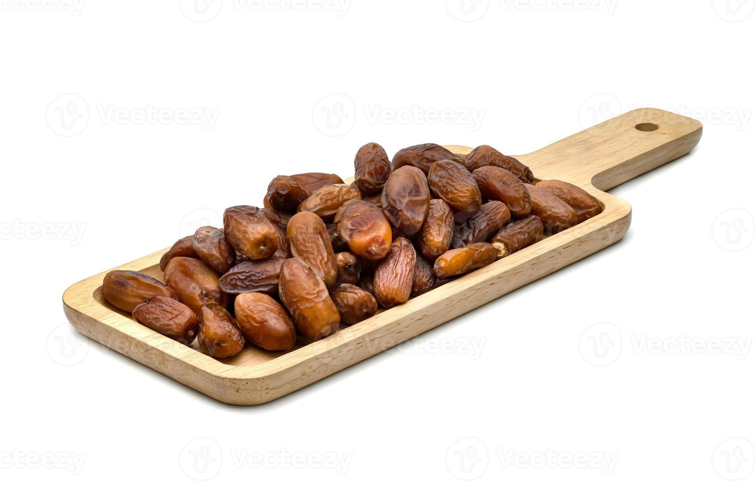 dry dates palm in wooden tray isolated on white background. photo