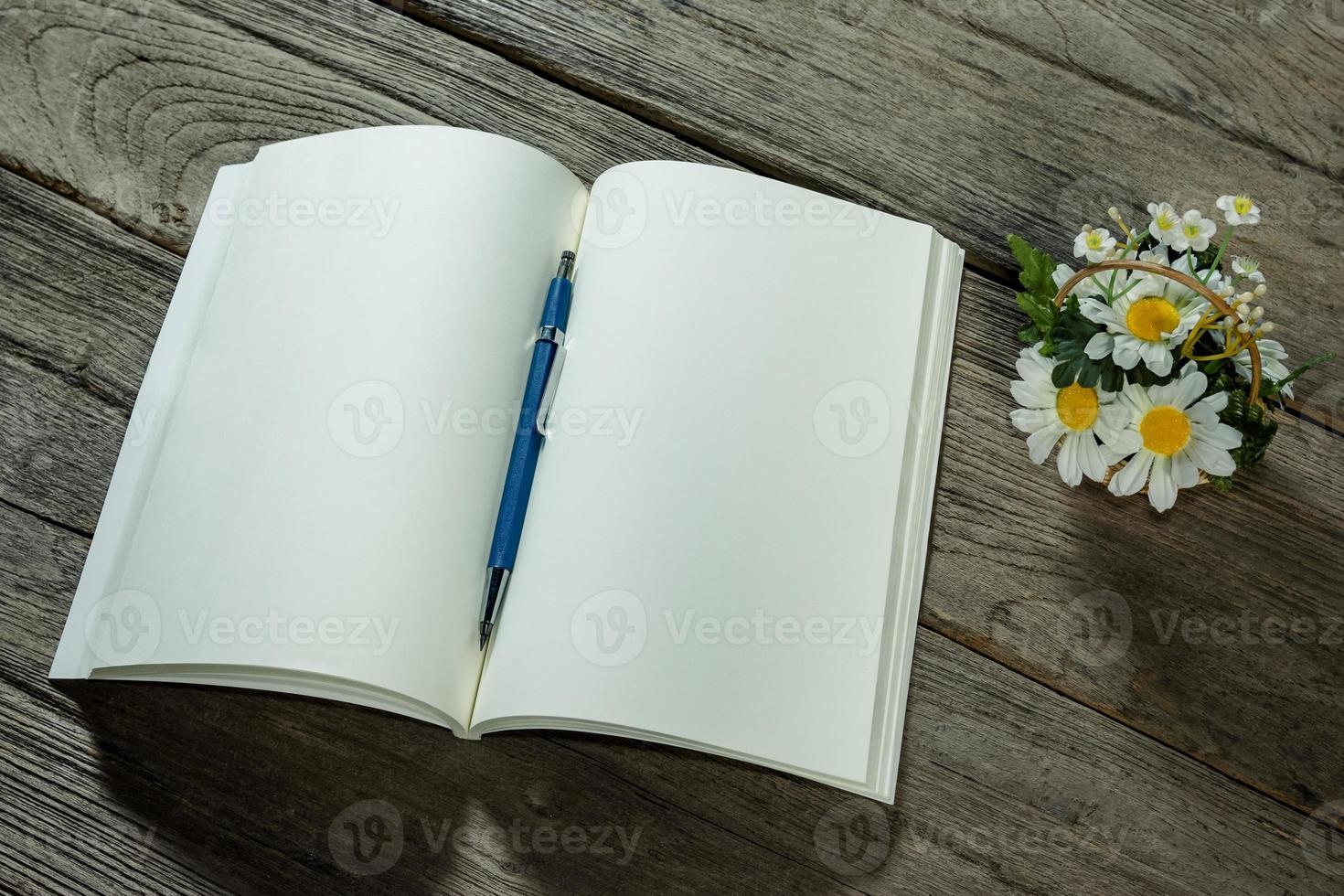 open note book with clutch-type pencil on wood background photo