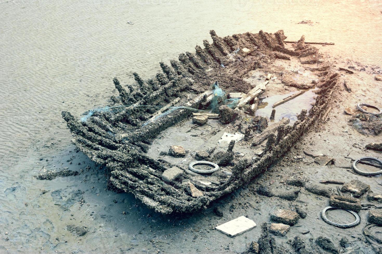 Old abandoned wooden boat on the beach photo