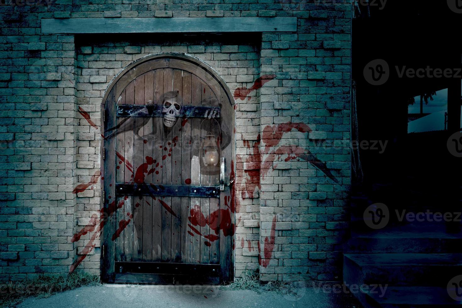 puerta de madera antigua en la pared de ladrillo con parca, día de halloween, casa embrujada foto