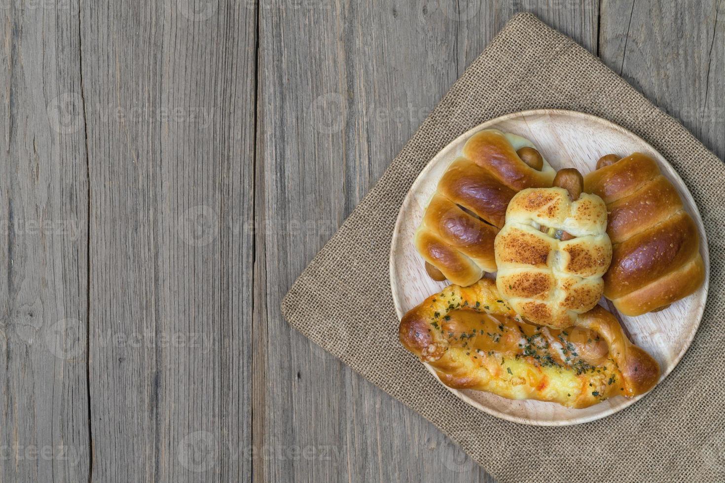 various fresh cheese sausage bread with sack on wooden background,top view photo