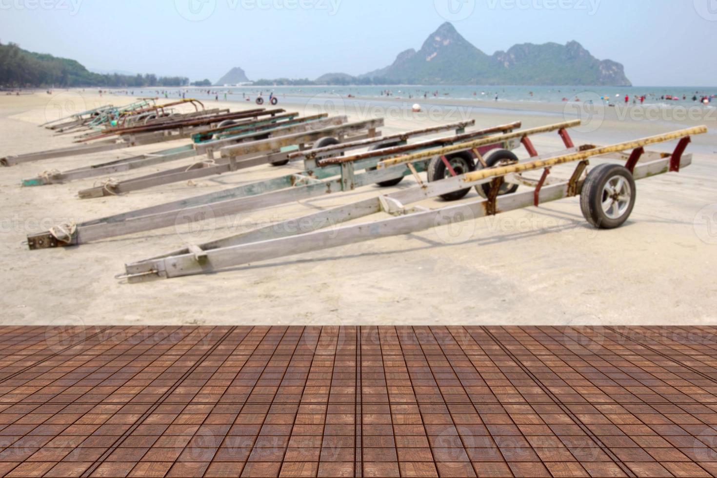 Wooden table with blur trailer for boats on the beach background photo