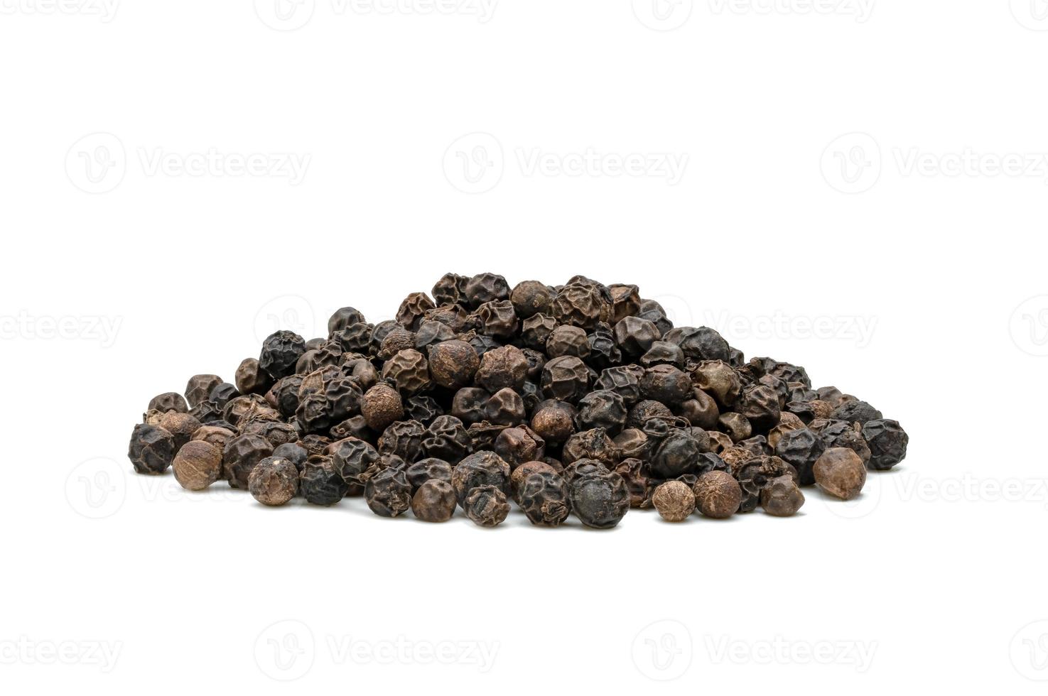 pila de pimienta negra o semillas de granos de pimienta negra aisladas en fondo blanco. foto
