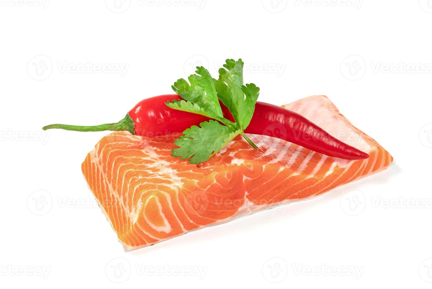 Piece of fresh salmon fillet sliced with coriander leaves and red pepper isolated on white background photo