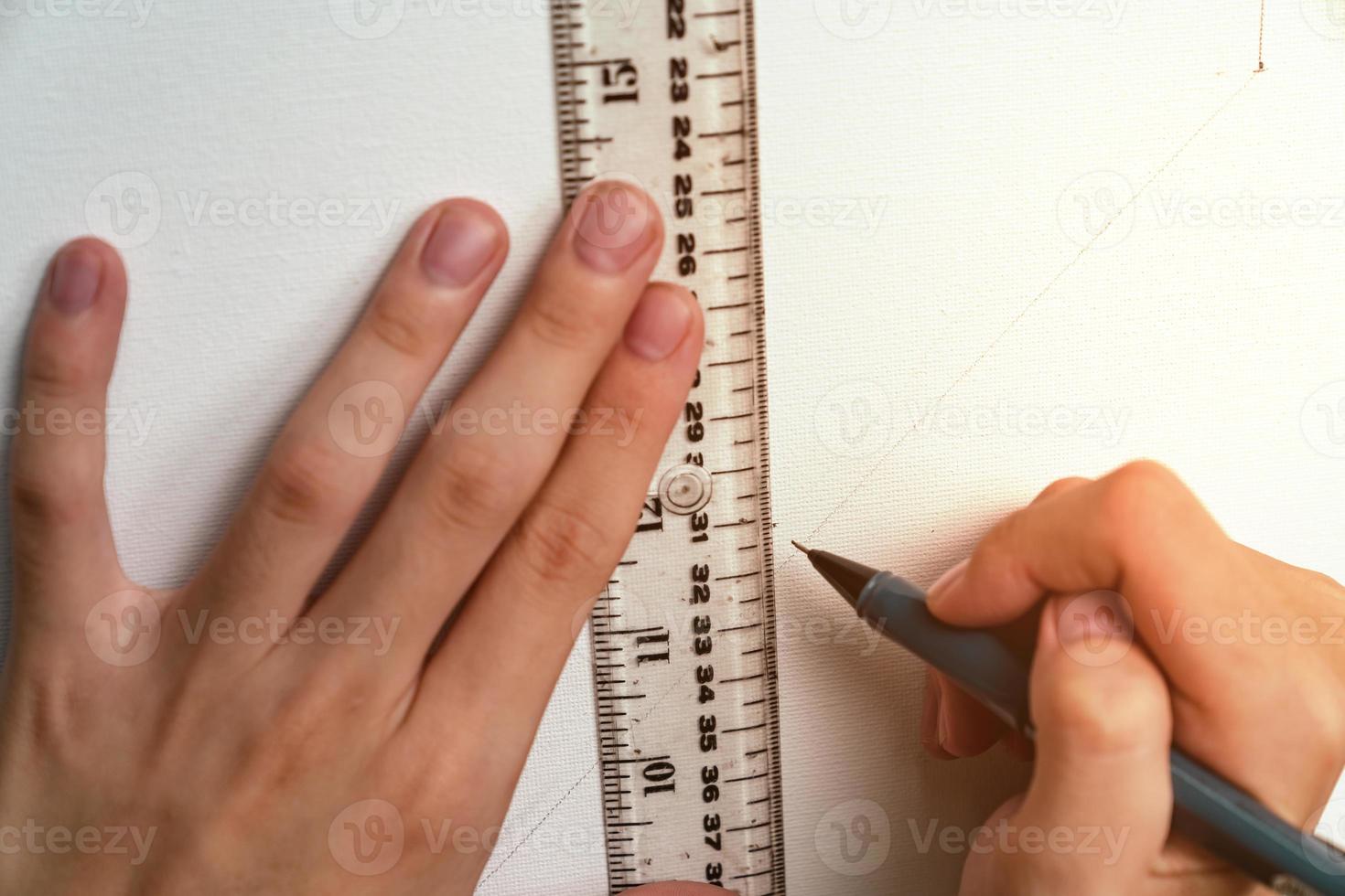 hand holding ruler and clutch-type pencil with canvas background photo