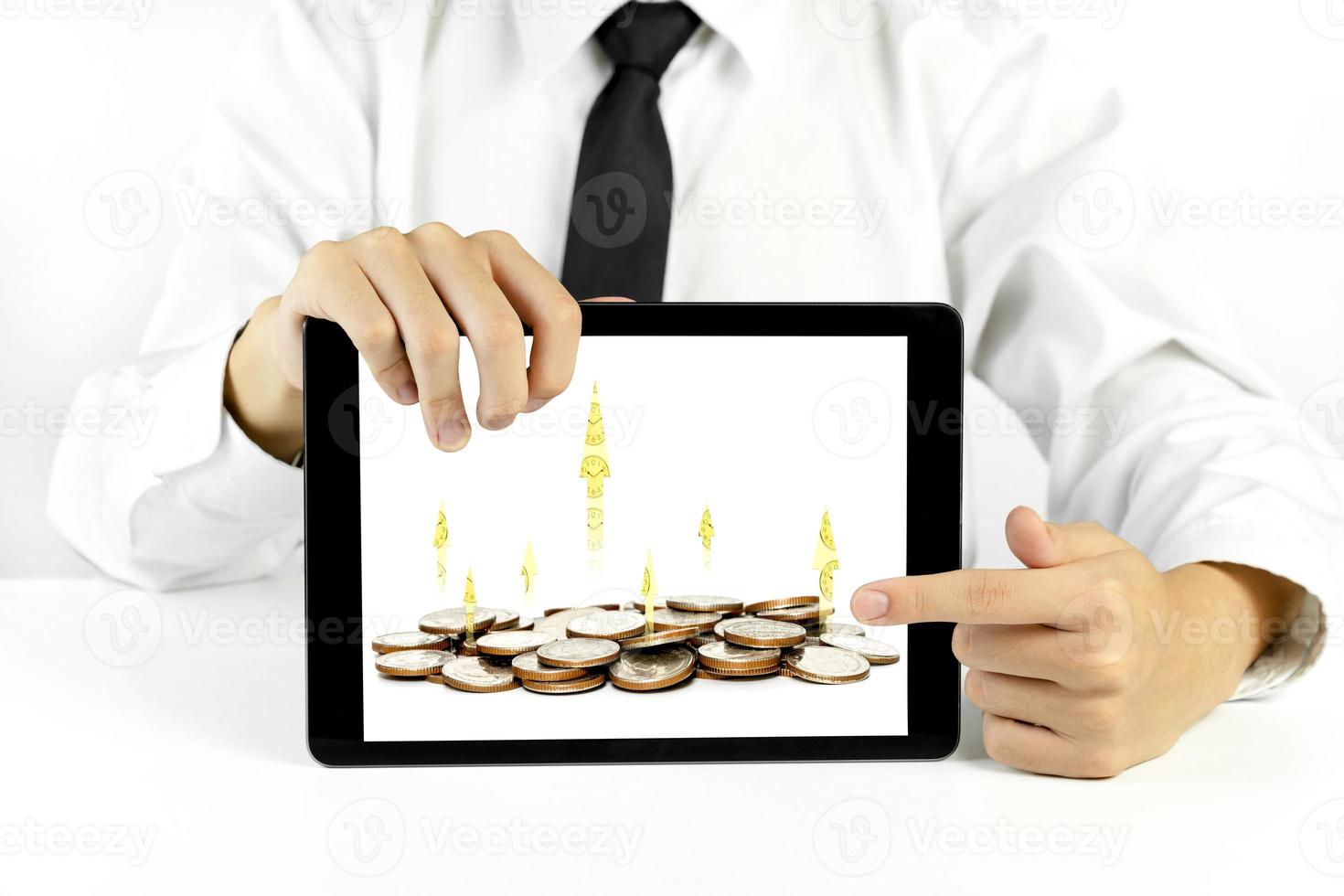 Businessman holding a tablet with coins and chart of indicators in business,economic growth concept photo