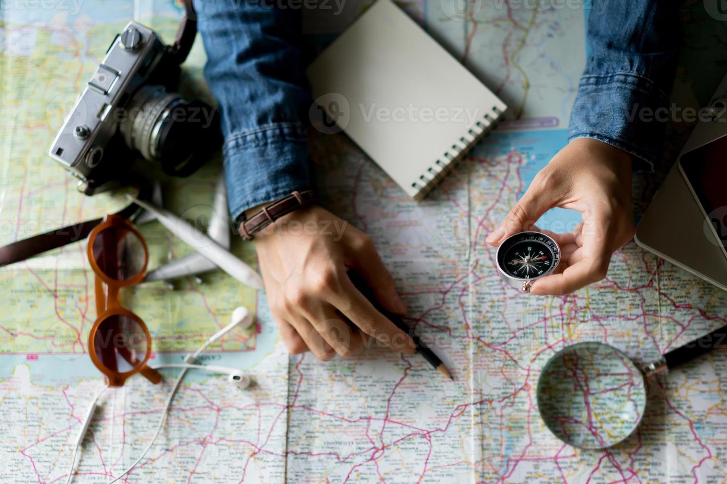 Hand holding compass for planning vacation trip and accessories for travel photo