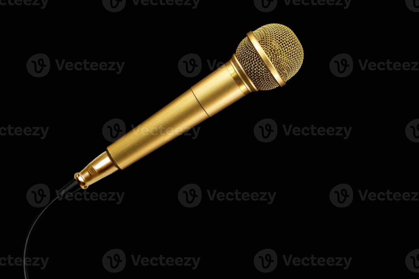 Golden microphone with cable on black background. photo