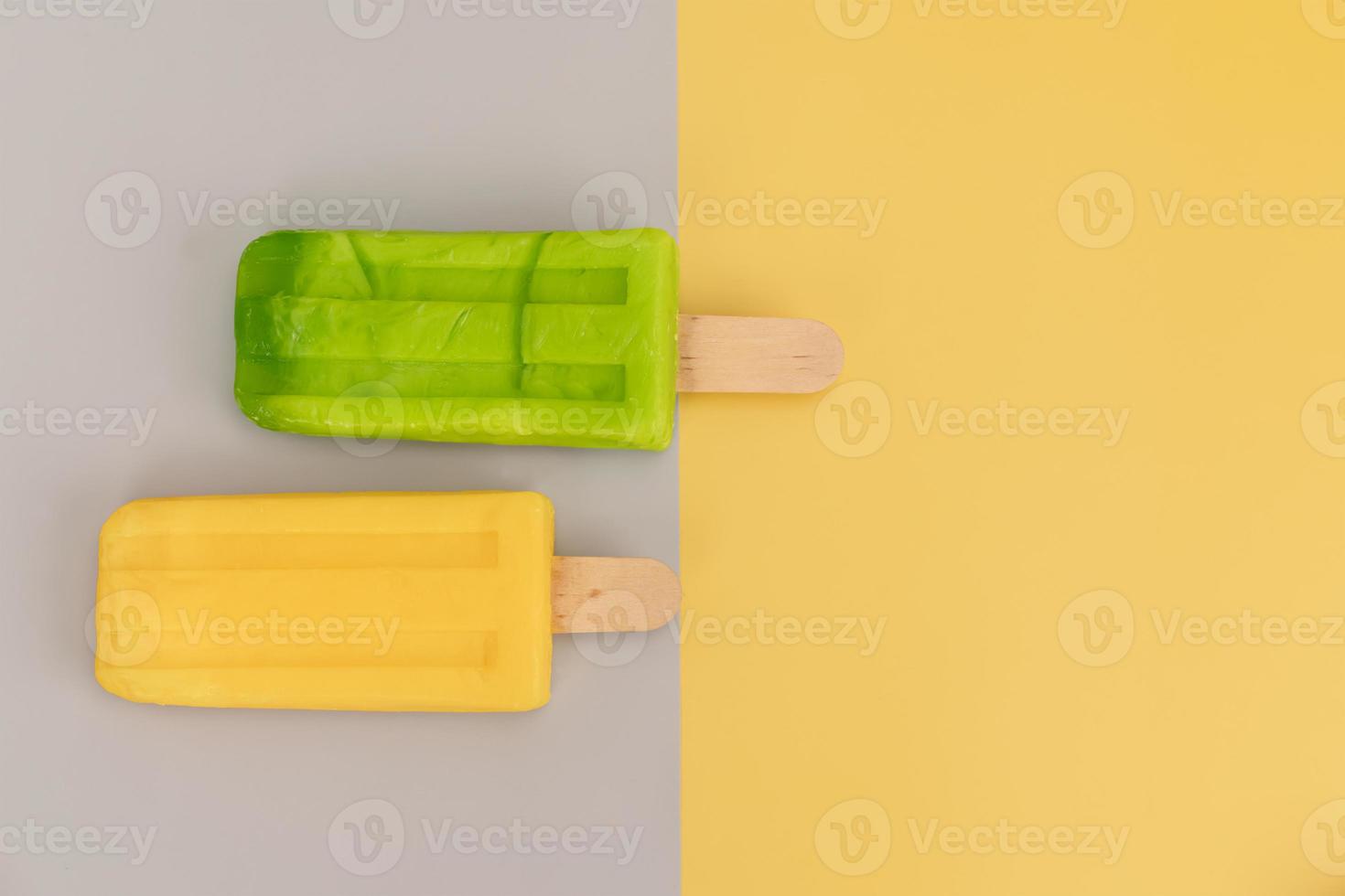 Ice cream stick on gray and yellow background. photo