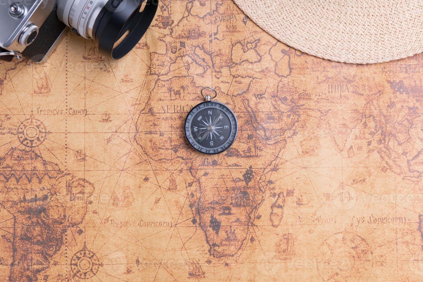 Compass on map with vintage camera and hat for traveler photo