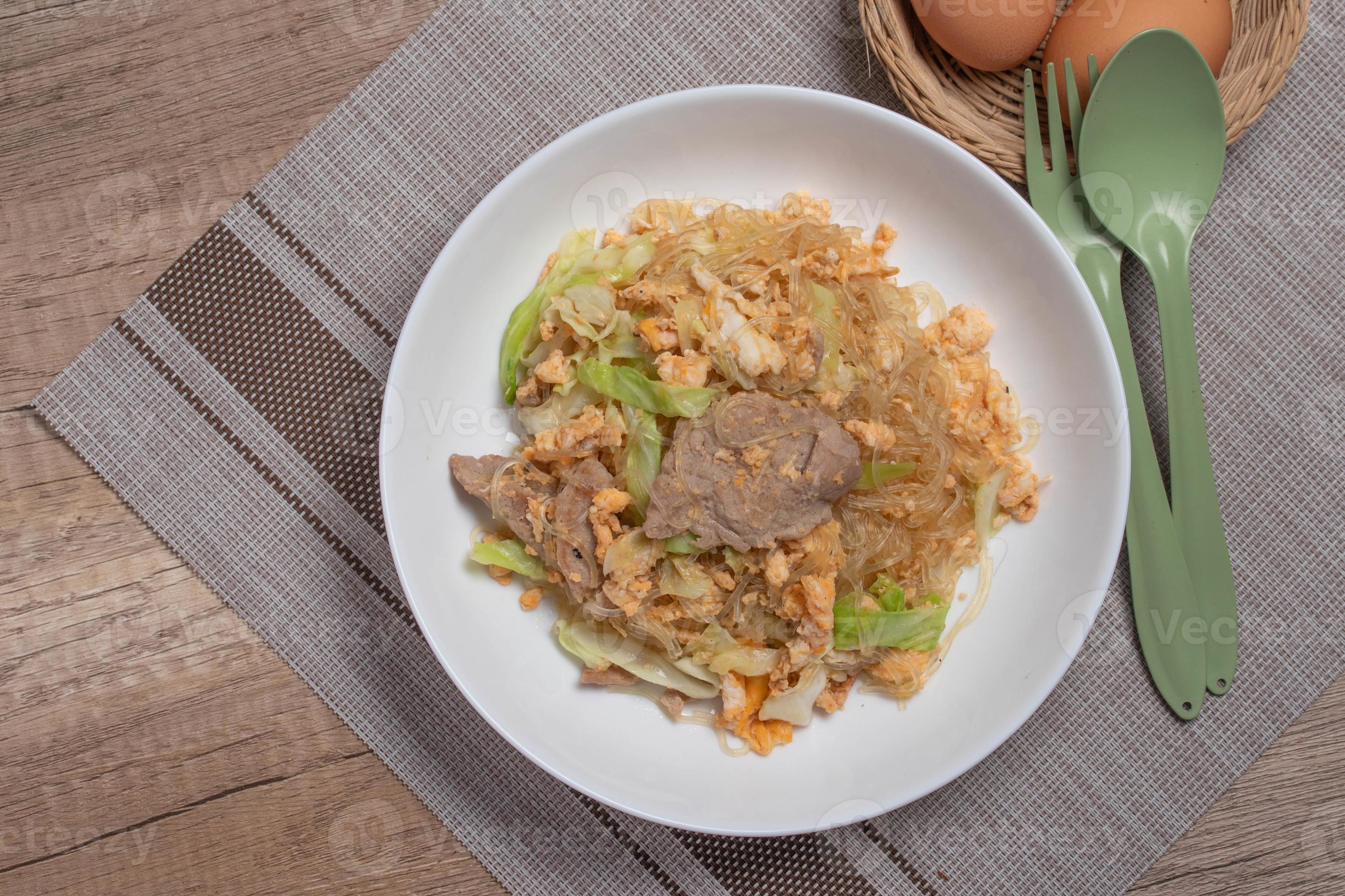 Stir fried vermicelli with pork, egg and collard greens in a white