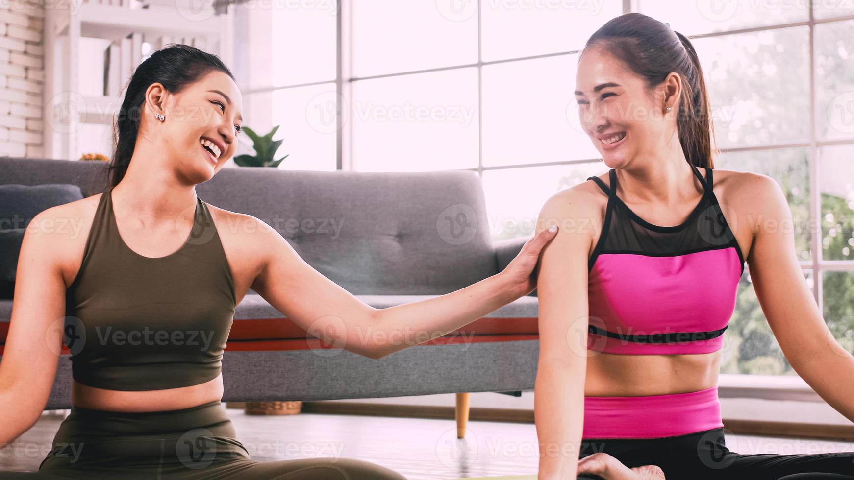 dos chicas asiáticas haciendo ejercicios de yoga en casa. foto