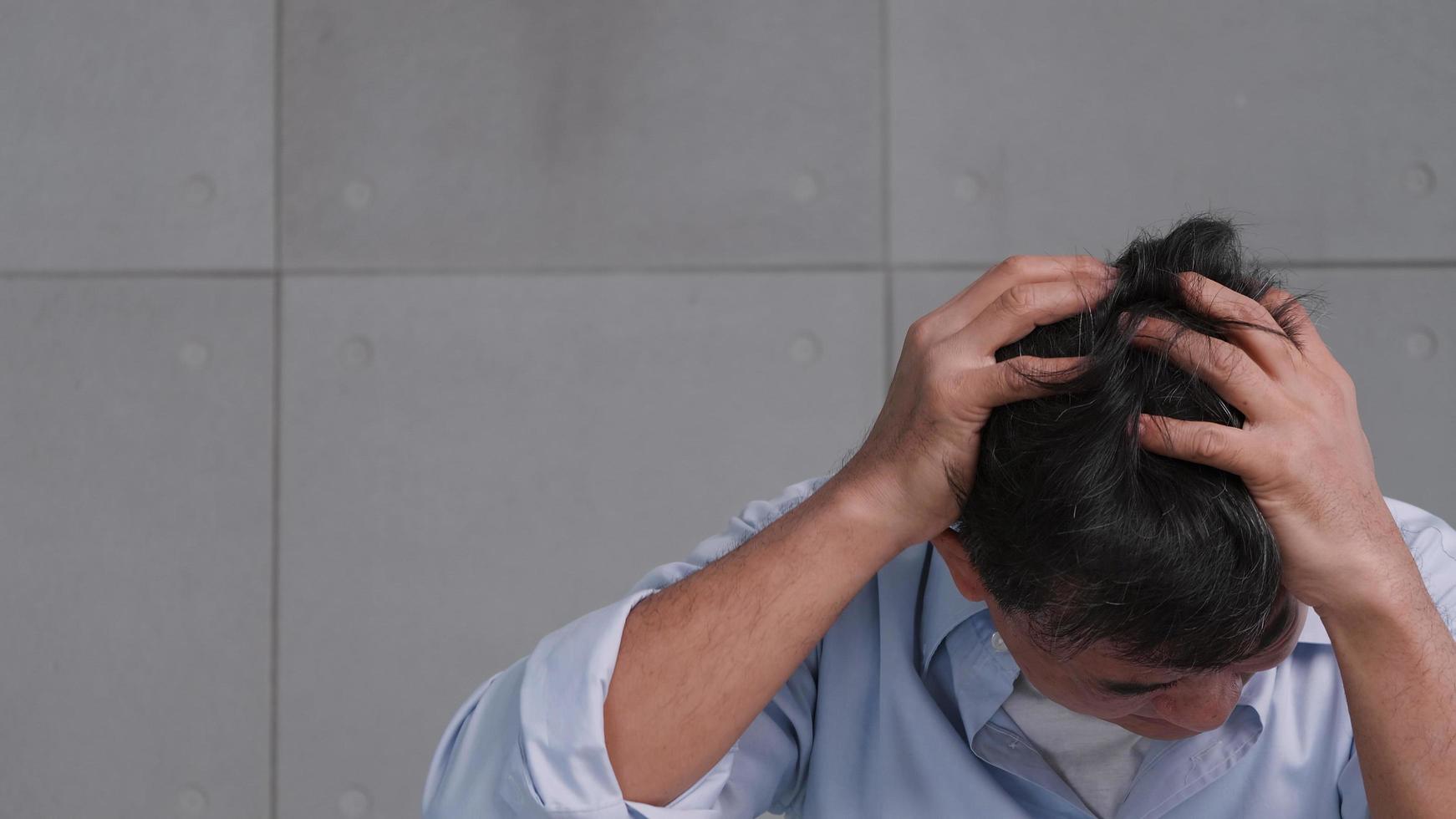 anciano asiático con dolor de cabeza por migraña. el hombre se siente estresado y preocupado por los problemas de salud. foto