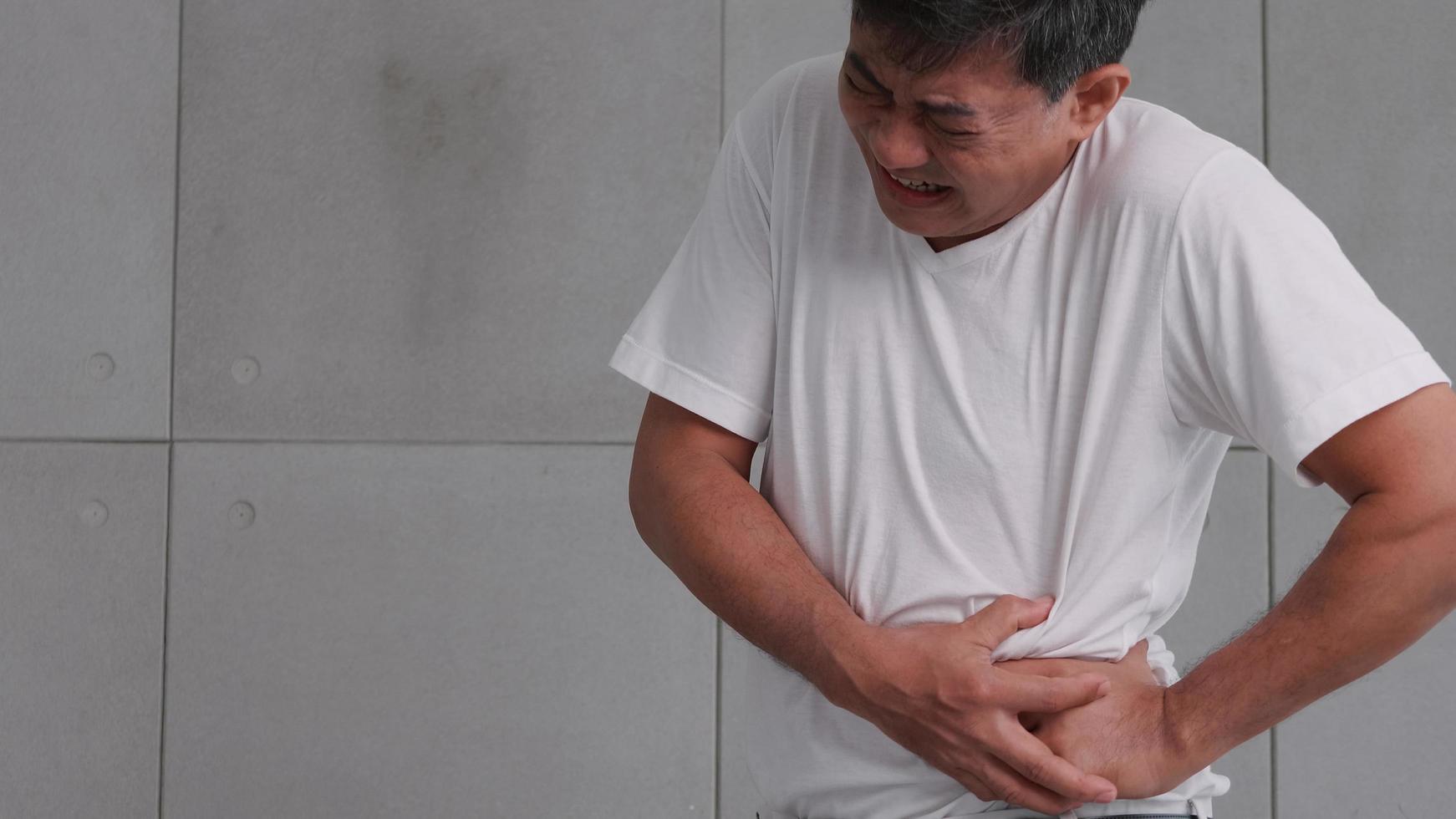 Asian man has severe stomach pains caused by appendicitis. photo