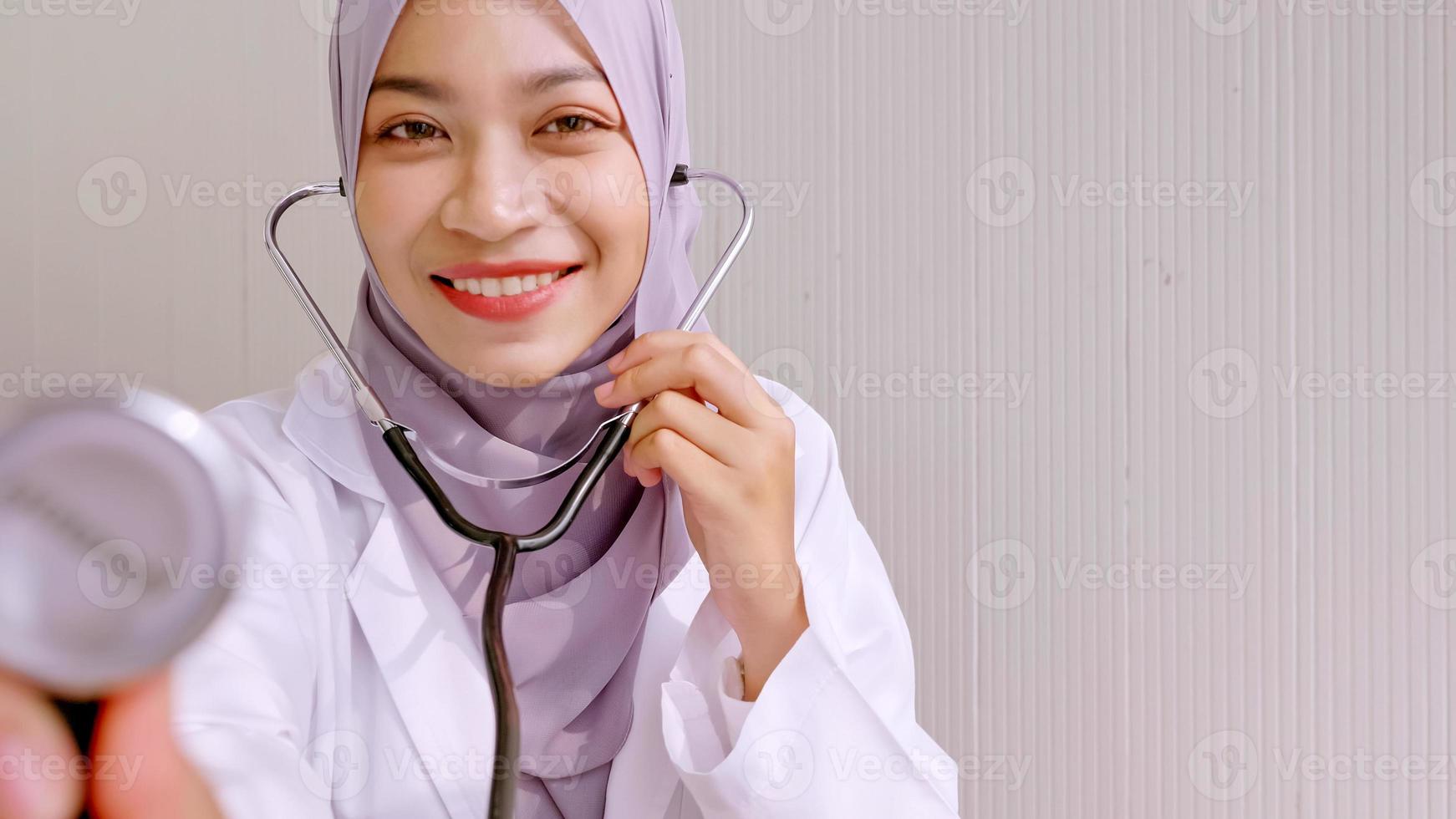 Muslim female doctor checking up patient's health at hospital room. photo
