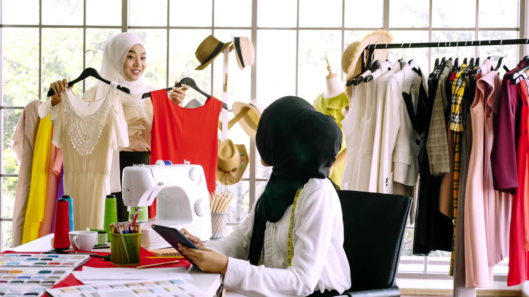 hermosas mujeres musulmanas trabajando juntas en la oficina de ropa. foto