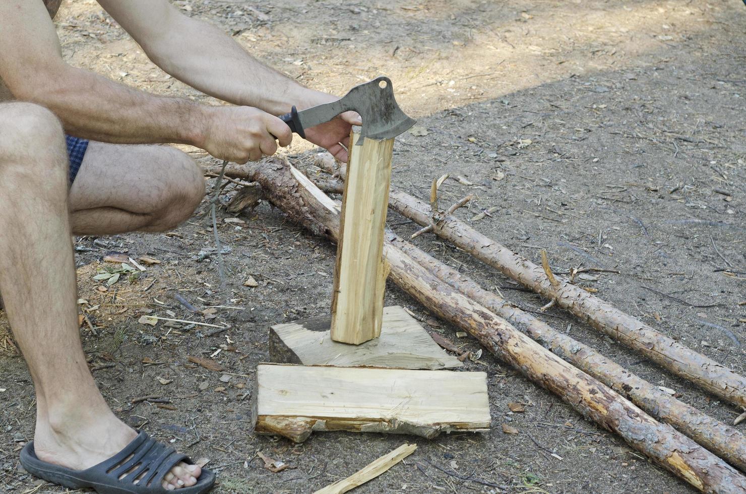 a man chops wood with an axe for heating. photo