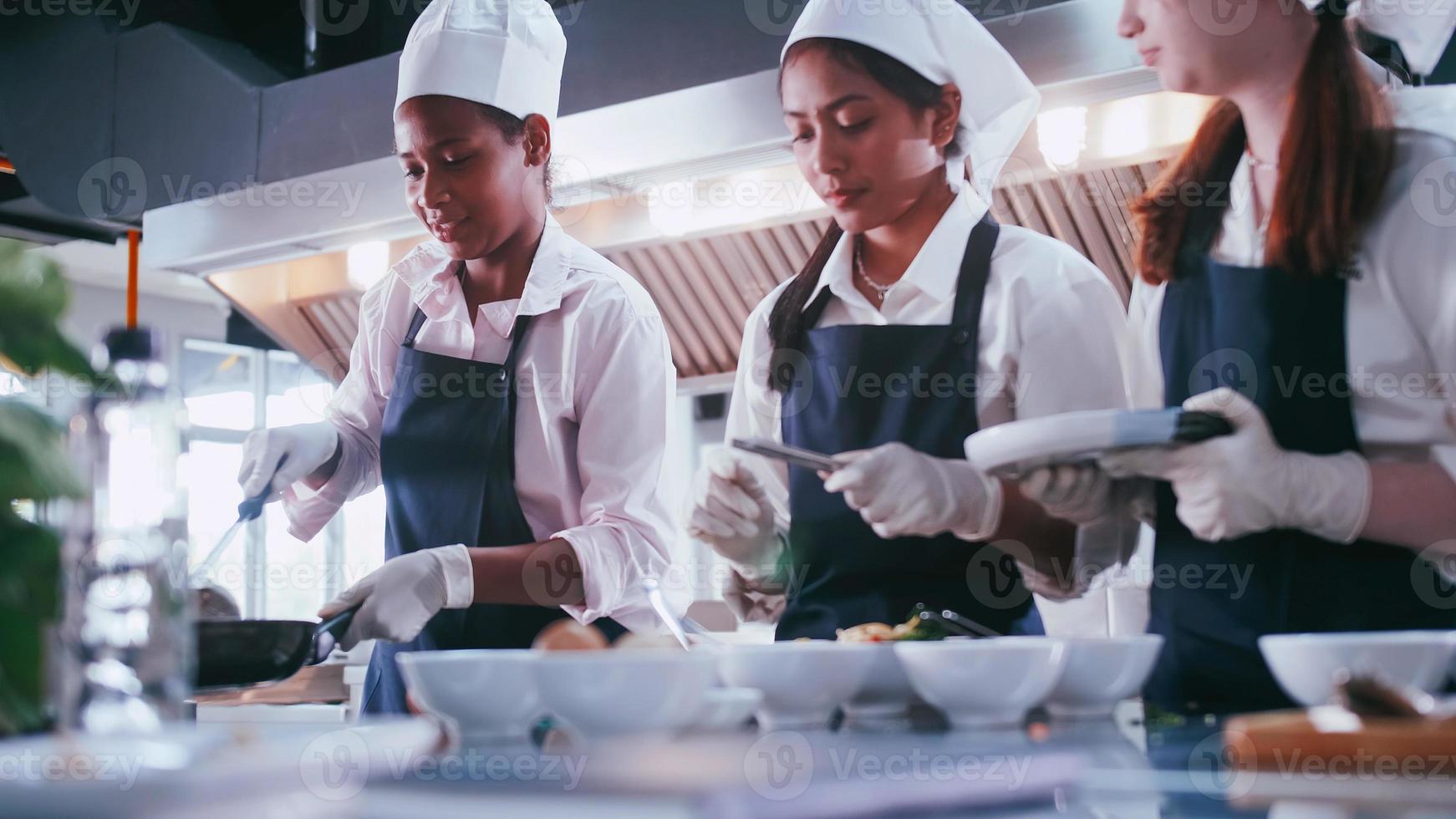 Group of schoolgirls having fun learning to cook. Female students in a cooking class. photo