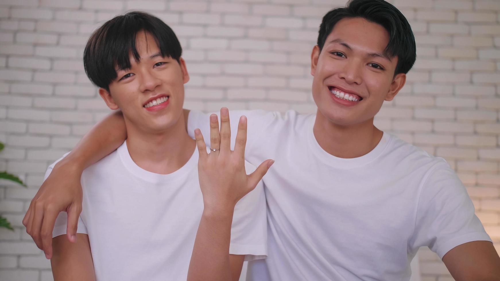 feliz pareja asiática gay mostrando su anillo de bodas. foto