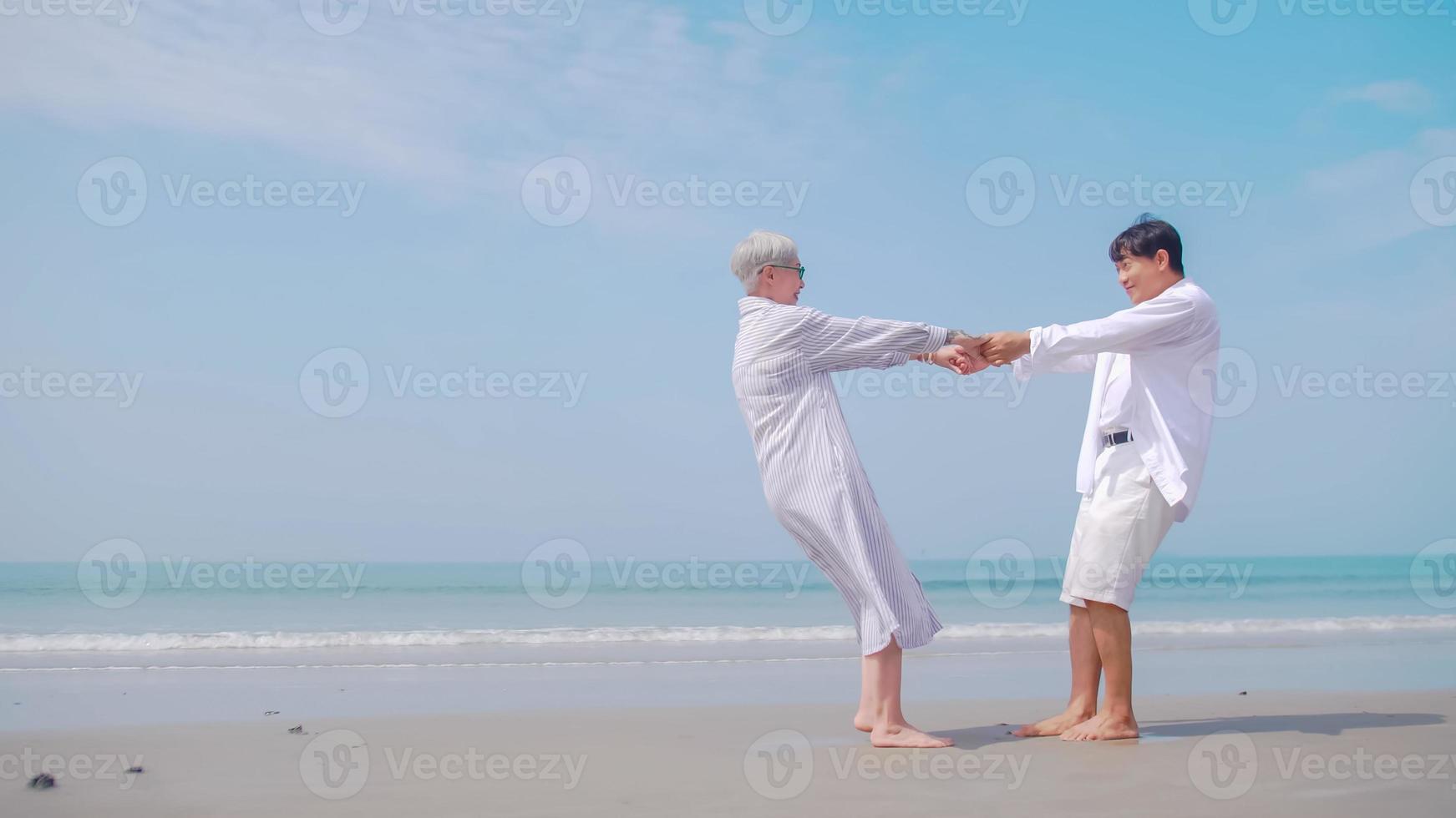 pareja de jubilados asiáticos relajándose junto al mar en verano. una  anciana bailando con su pareja en la playa. 11098240 Foto de stock en  Vecteezy